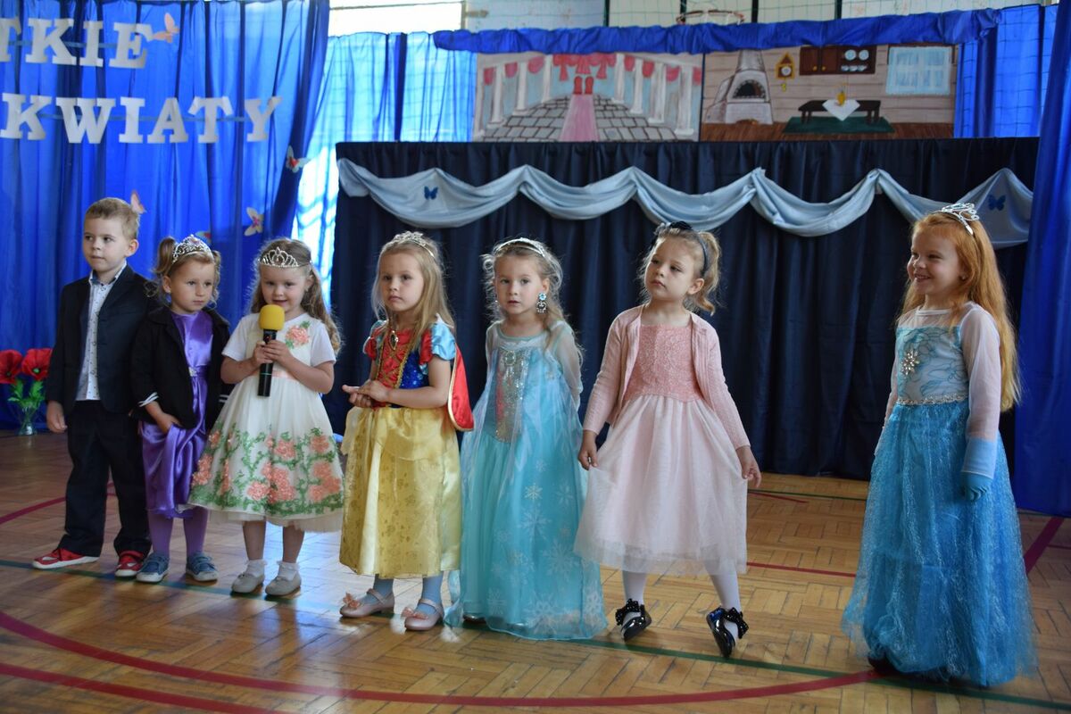 Zdjęcie przedstawia dzieci w wieku przedszkolnym z mikrofonami, mówiące wierszyki