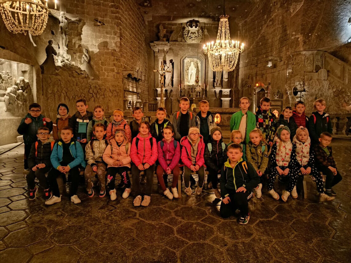 Grupa dzieci pozuje do wspólnego zdjęcia w kopalni soli w Wieliczce. 
